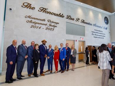 County Officials standing in front of a stone wall with a dedication to the Honorable Lisa P. Thornton